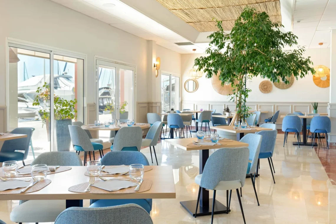 Salle de restaurant lumineuse avec tables dressées.
