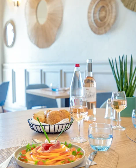 Table dressée avec plat et vin rosé
